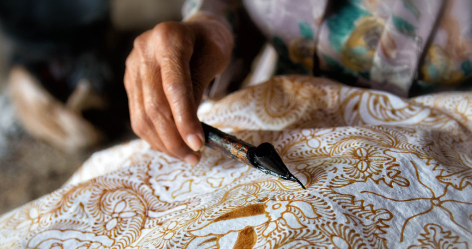 A woman working on Batik painting