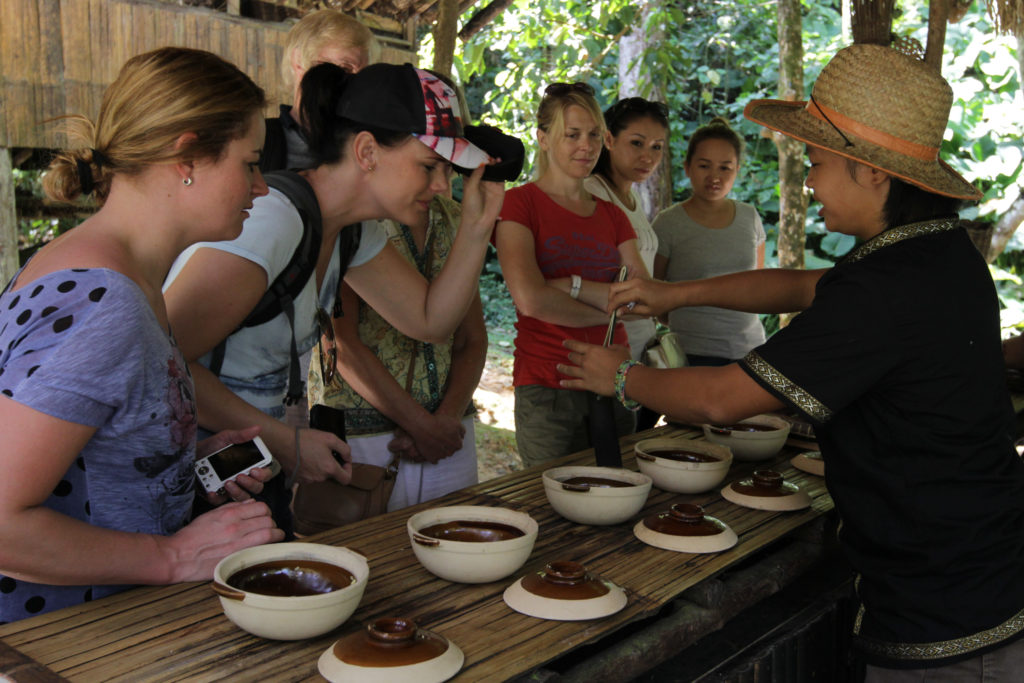 A group of tourists observing traditional cooking