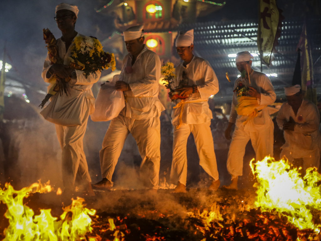 A group of devotees walking over a bed of ht coals